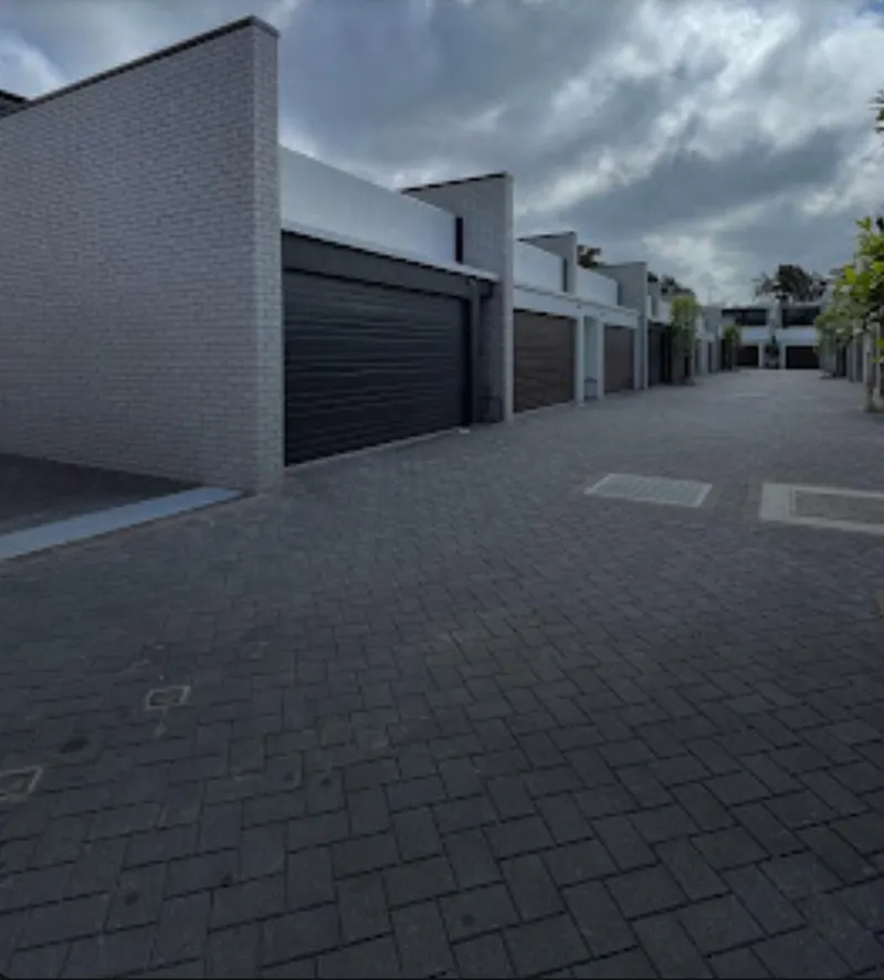 New townhouse development with painted brick and render along a private lane